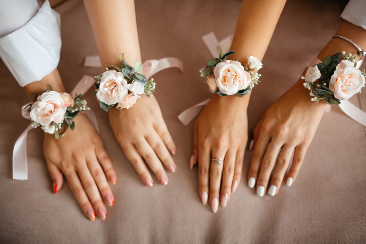 hands of four women with tied flowers on their hands